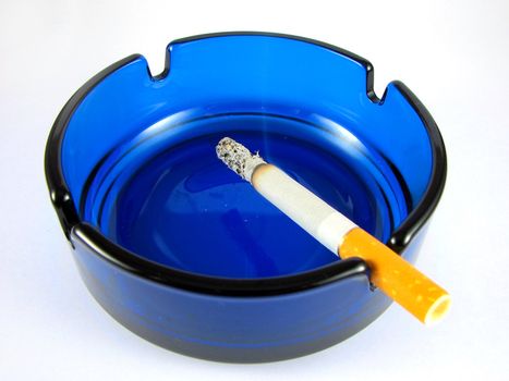 Ashtray with lit cigarette isolated on white