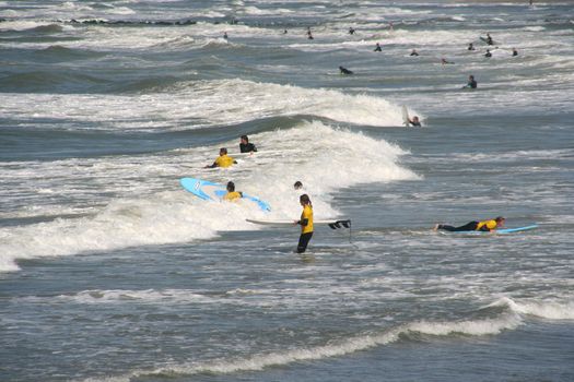 Surfschool: people learning how to surf in the shallow water