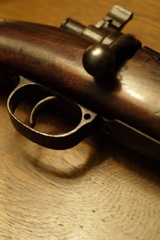 Very shallow depth of field image of the trigger of an old shotgun.  Focus is on the tip of the trigger.
