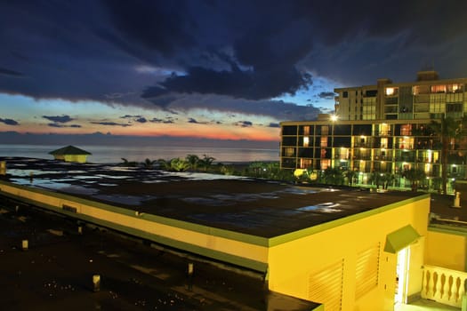 A sunset reflected in the puddles on a building of a hotel.