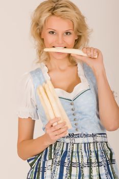 Beauty in Bavarian costume with asparagus in her hand