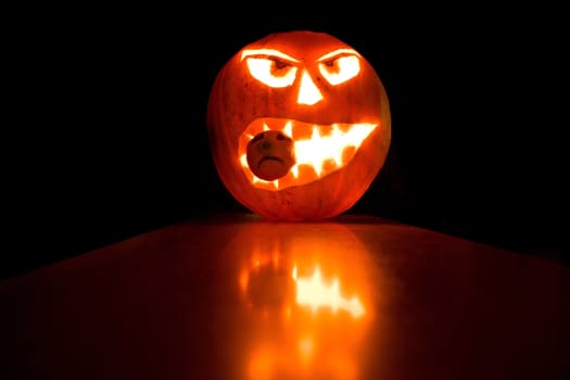 Halloween pumpkin light in the dark background, with reflections