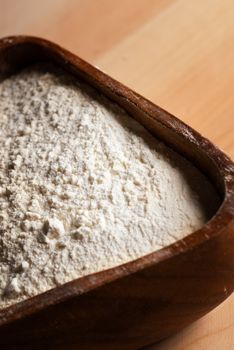 Wooden pot filled with baking powder under golden light