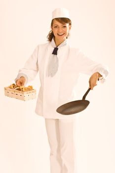 female chef with a basket full of mushrooms and pan