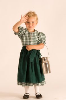 Little girl with blond curly hair Bavarian in traditional dress with milk jug