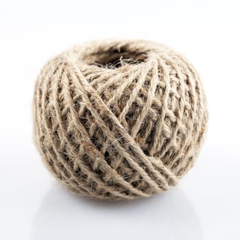 Ball of brown twine on plane background.