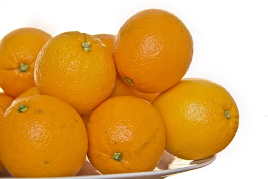 Delicious ripe Florida oranges stacked up on a white plate