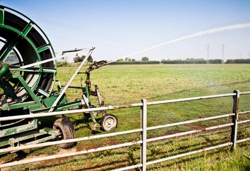 Irrigation operations in Italian country during a sunny day