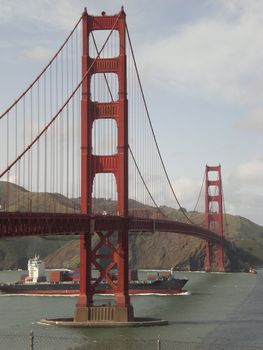 A cargo ship passes underneath the Golden Gate Bridge in San Francisco, California