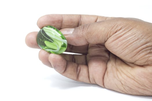 A beautiful green and white marble held by hand for display