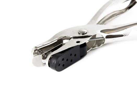 A shiny silver paper hole puncher on a white background