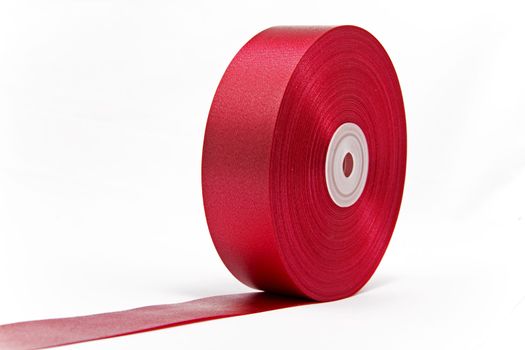 A roll of shiny red ribbon unrolled like a giant red carpet 