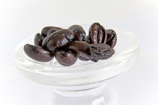 Roasted glossy coffee beans on a white background