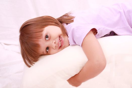 Beautiful little girl lying on bed