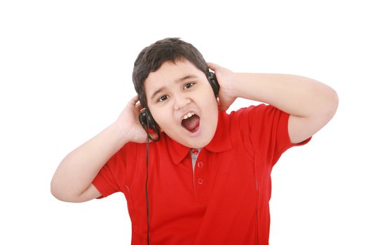 Portrait of a sweet young boy listening to music on headphones against white background