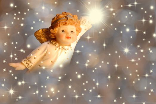 Christmas Card Angel with a light hand on starry background