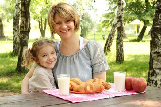 happy mother and daughter with healthy breakfast