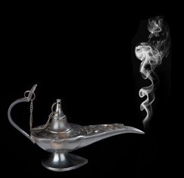 Genie lamp with a smoke - symbol of the rapid success. Isolated on black