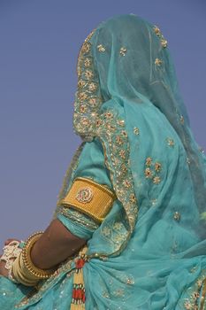 Lady dressed in ornate blue sari with gold and silver trim. Desert Festival Jaisalmer Rajasthan India
