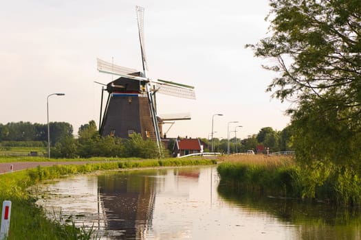 Dutch windmills with reflection after sunrise in spring - horizontal