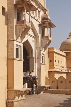 Mahout rides a decorated elephant out of the entrance of Amber Fort in Jaipur, Rajasthan, India.