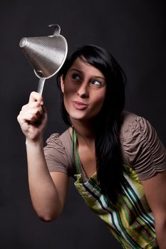 young woman looking in a sieve