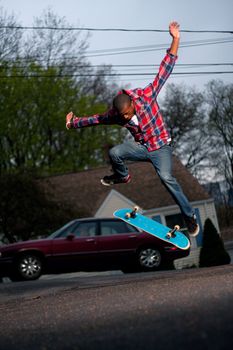 A skateboarder performing jumps or ollies on asphalt.  Slight motion blur showing the movement on the arms and legs.