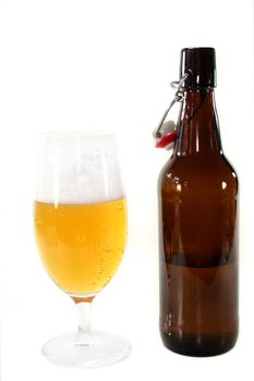 a glass of beer and a bottle in front of white background
