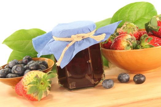 berry marmalade with different berries on a wooden board