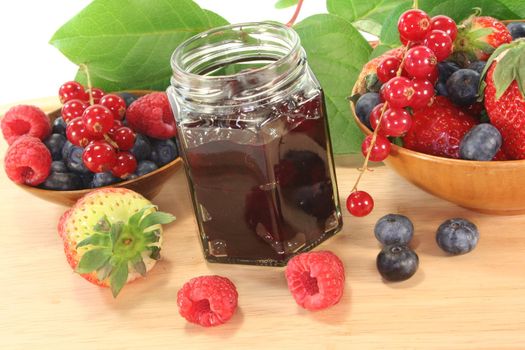 berry marmalade with different berries on a wooden board