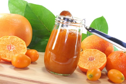 Orange marmalade with different Citrus fruits on a wooden board