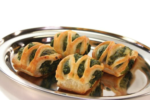 Puff pastry with spinach and cheese filling on a silver tray