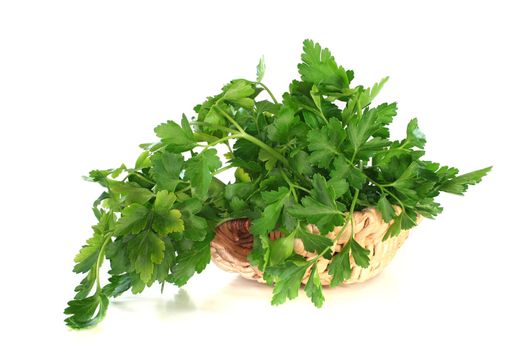 a bunch of parsley in a basket on a white background
