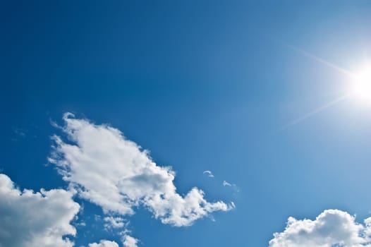 White cloud in the form of a dragon's head and the sun on the background blue sky 