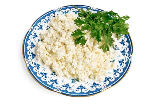 Curd in a porcelain dish with a few sprigs of parsley isolated on a white background