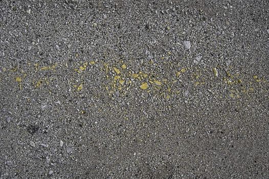 Gray gravel with a strip of yellow paint (texture)