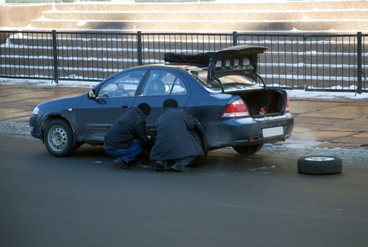 Replacing the wheels of a car on the road. Urban landscape.