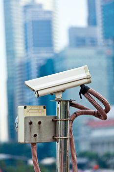 CCTV surveillance camera in Singapore with skyscapers in background