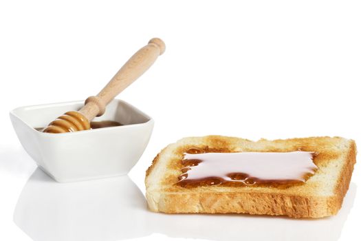 toast with honey an a honey jar with a honey dipper on white background