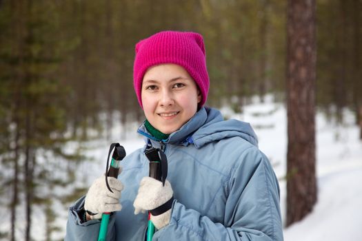 A young girl on a ski outing against the backdrop of the winter forest