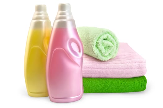 Two bottles of rinser pink and yellow, a stack of towels in isolation on a white background