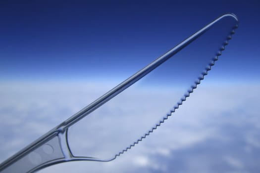 Clear plastic disposable knife against the sky