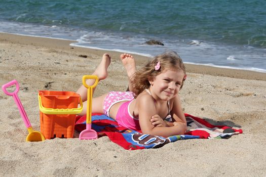 little girl lying on the beach