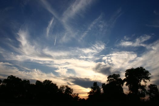 From the sinking sun illuminated clouds