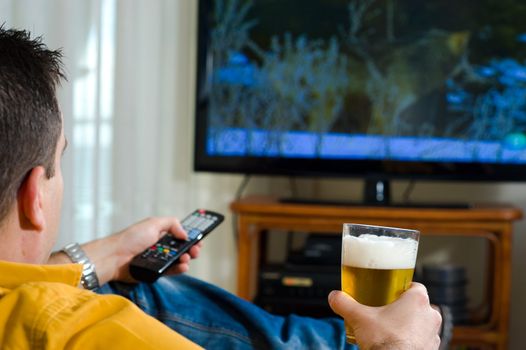 Guy enjoying his evening beer in front of the television