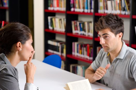 Woman asking her partner to be quiet in the library