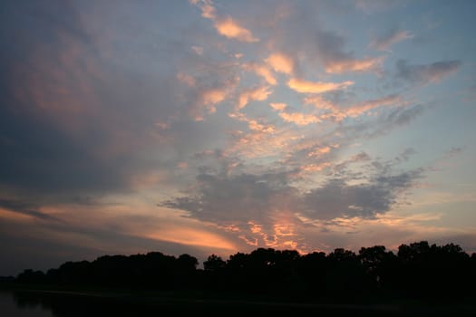 From the sinking sun illuminated clouds