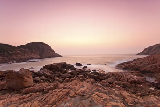 Sea stones along the coast at sunrise under long exposure