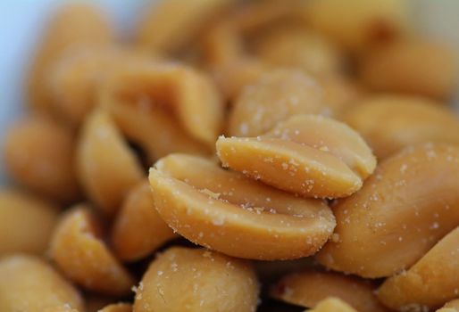 A bunch of salted peanuts in a closeup