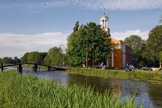 Church, bridge and country road with motor bikes passing by